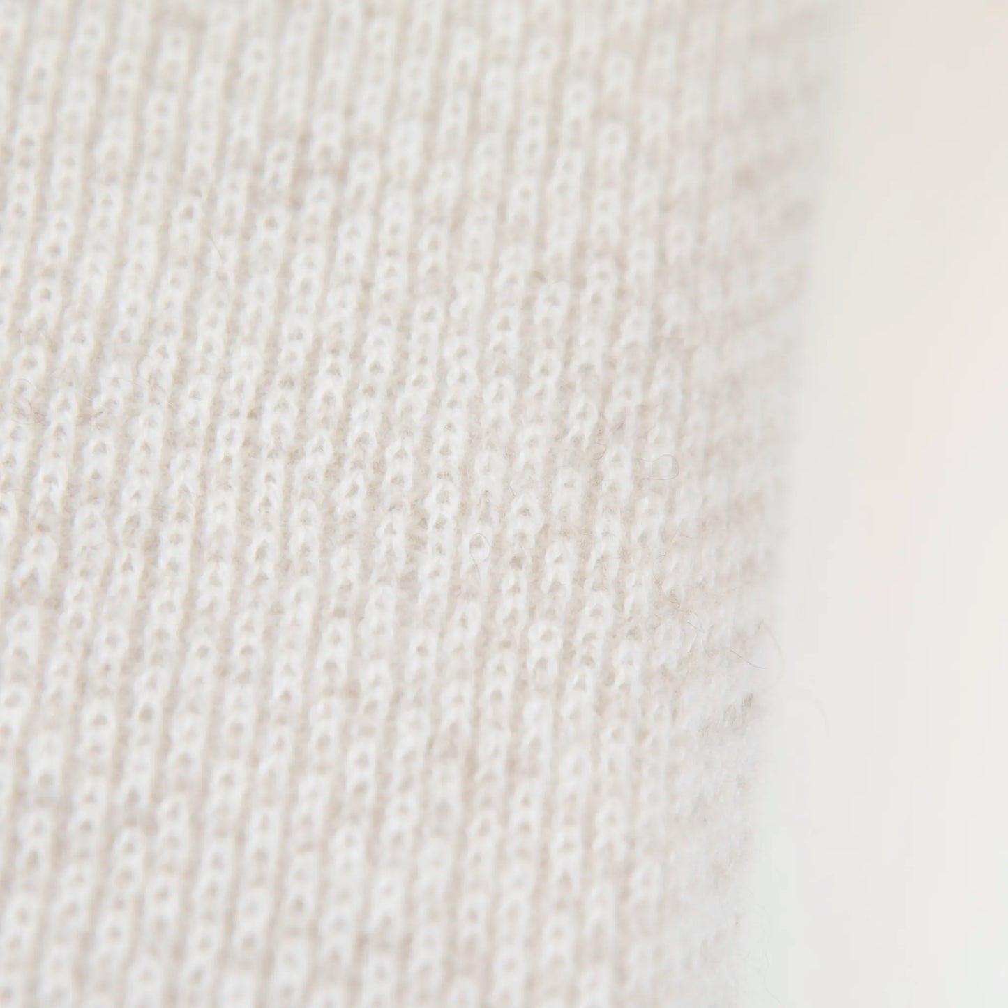 Dettaglio e texture tessuto della mantellina in 100% cashmere panna, Made in Italy, pratica e confortevole, con tre diverse vestibilità per adattarsi a ogni occasione.