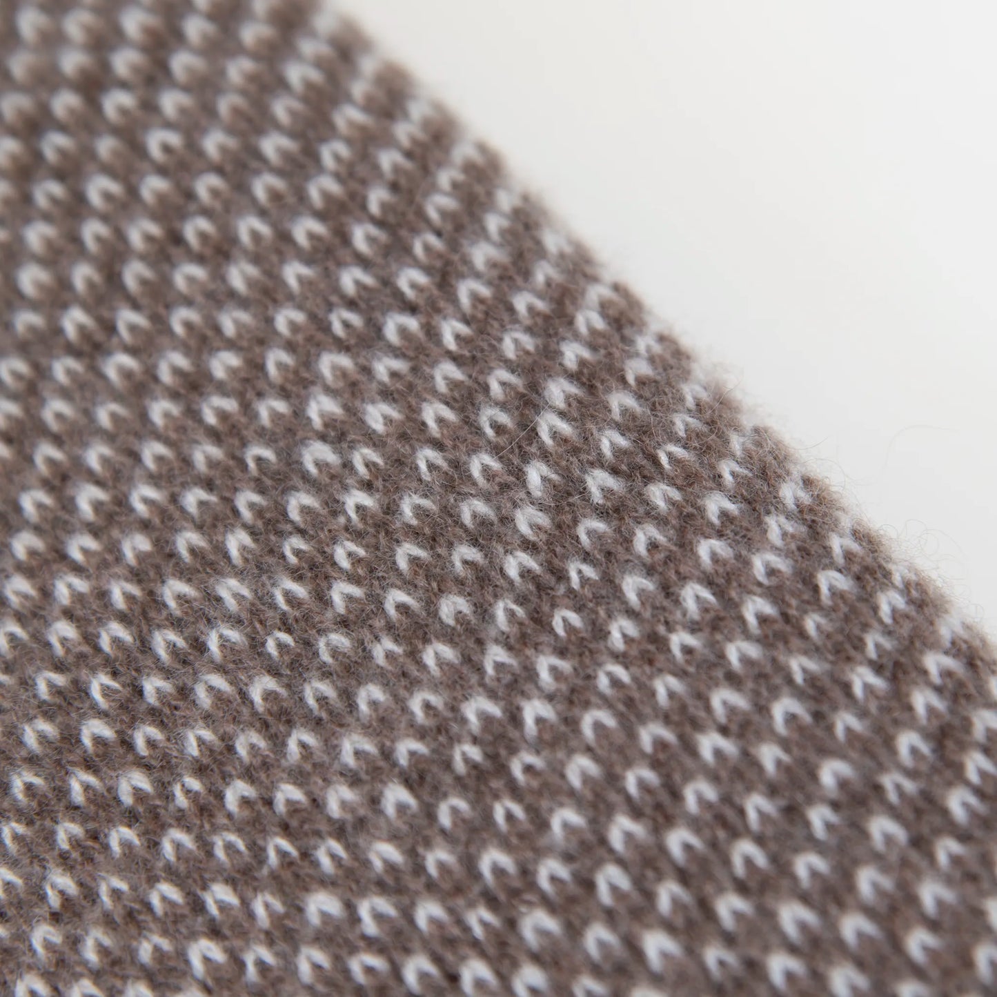 Dettaglio e texture tessuto della mantellina in 100% cashmere marrone e beige, Made in Italy, pratica e confortevole, con tre diverse vestibilità per adattarsi a ogni occasione.