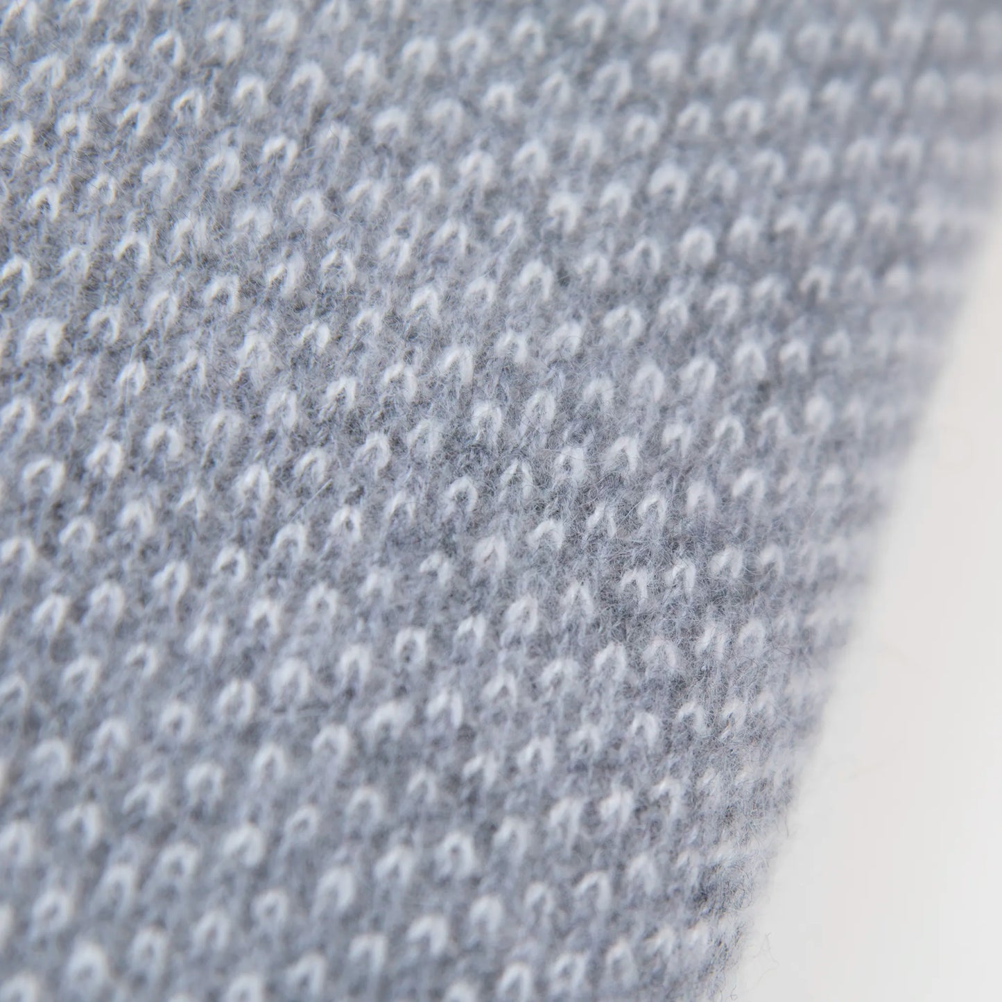 Dettaglio e texture tessuto della mantellina in 100% cashmere grigia, Made in Italy, pratica e confortevole, con tre diverse vestibilità per adattarsi a ogni occasione.
