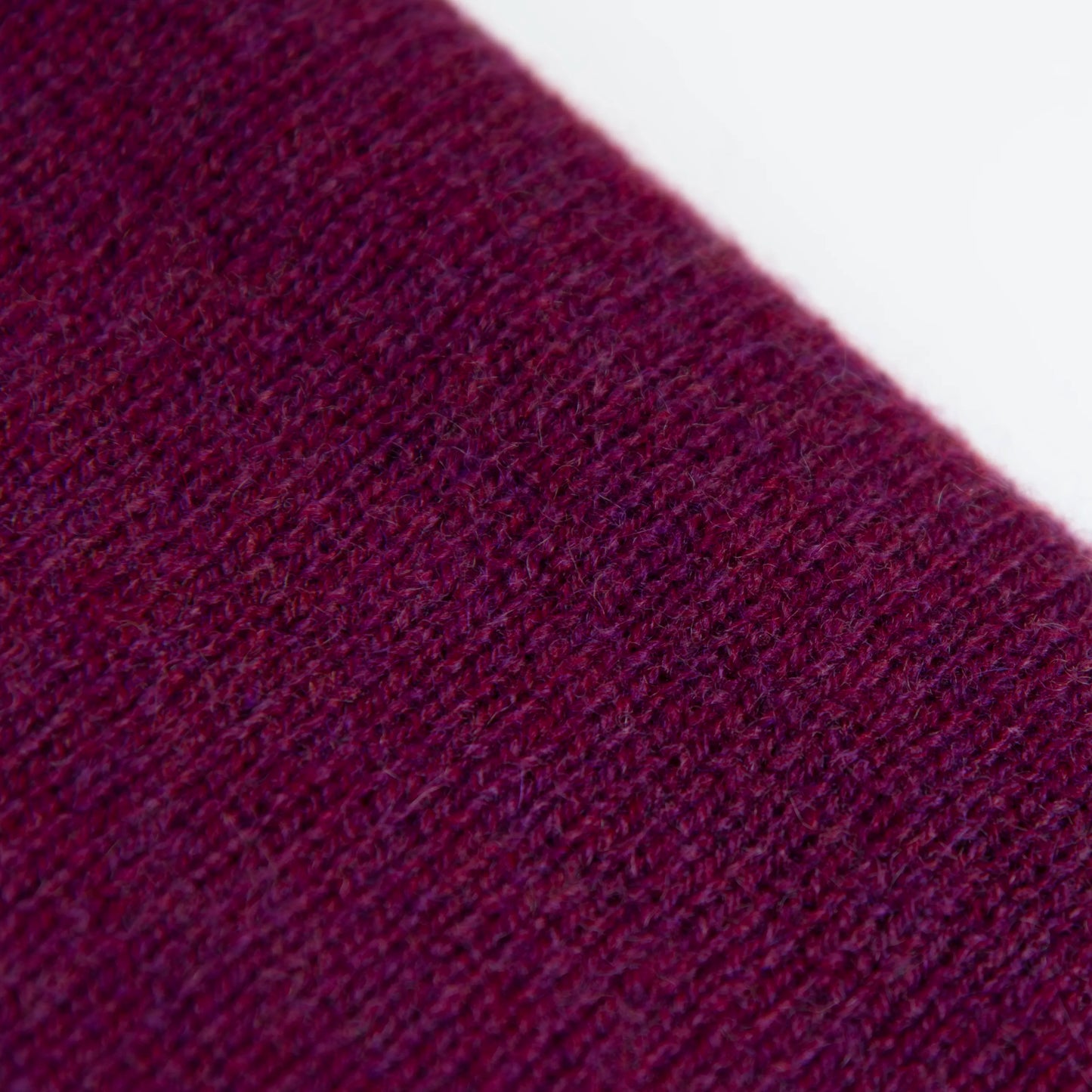 Dettaglio e texture tessuto della mantellina in 100% cashmere viola, Made in Italy, praticità e comfort con tre diverse vestibilità per ogni esigenza.