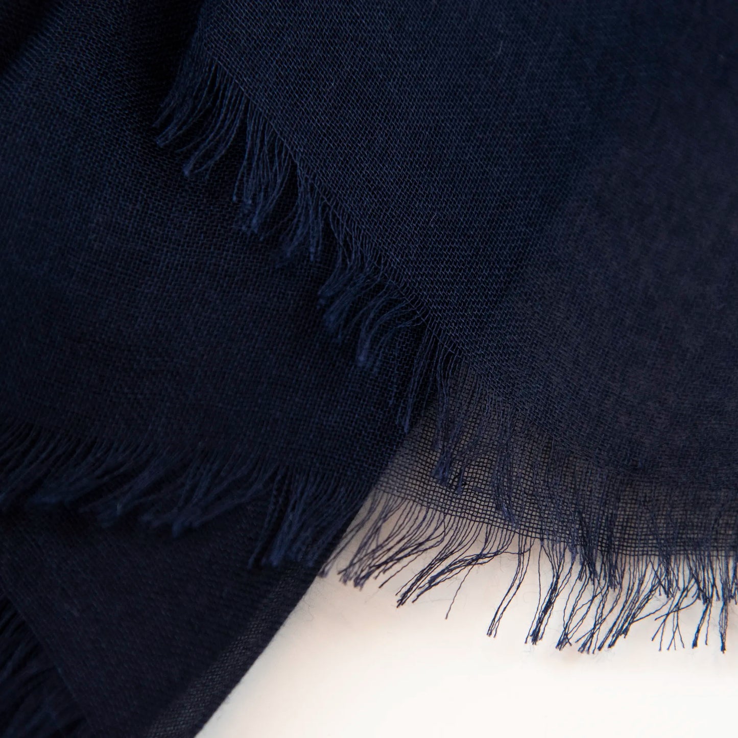 Dettagli e texture della Pashmina in 100% cashmere blu a tessitura twill, pregiata manifattura Made in Italy, sottile ed elegante adatta a ogni stagione.