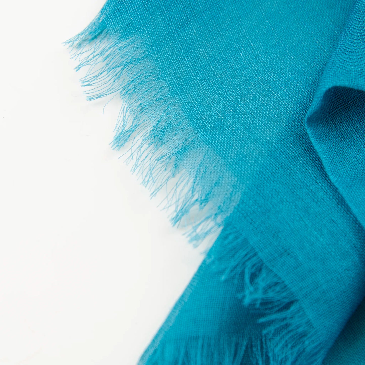 Dettagli e texture della Pashmina in cashmere e modal blu a tessitura twill, pregiata manifattura Made in Italy, sottile ed elegante adatta a ogni stagione.