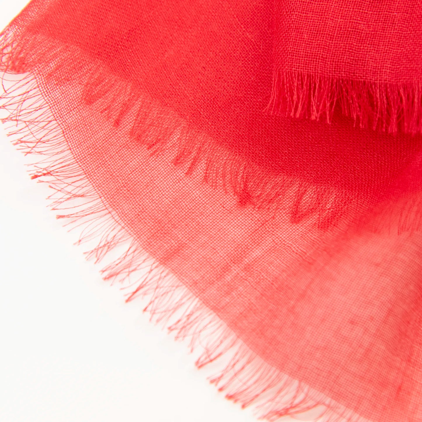 Dettagli e texture della Pashmina in cashmere e modal rossa a tessitura twill, pregiata manifattura Made in Italy, sottile ed elegante adatta a ogni stagione.