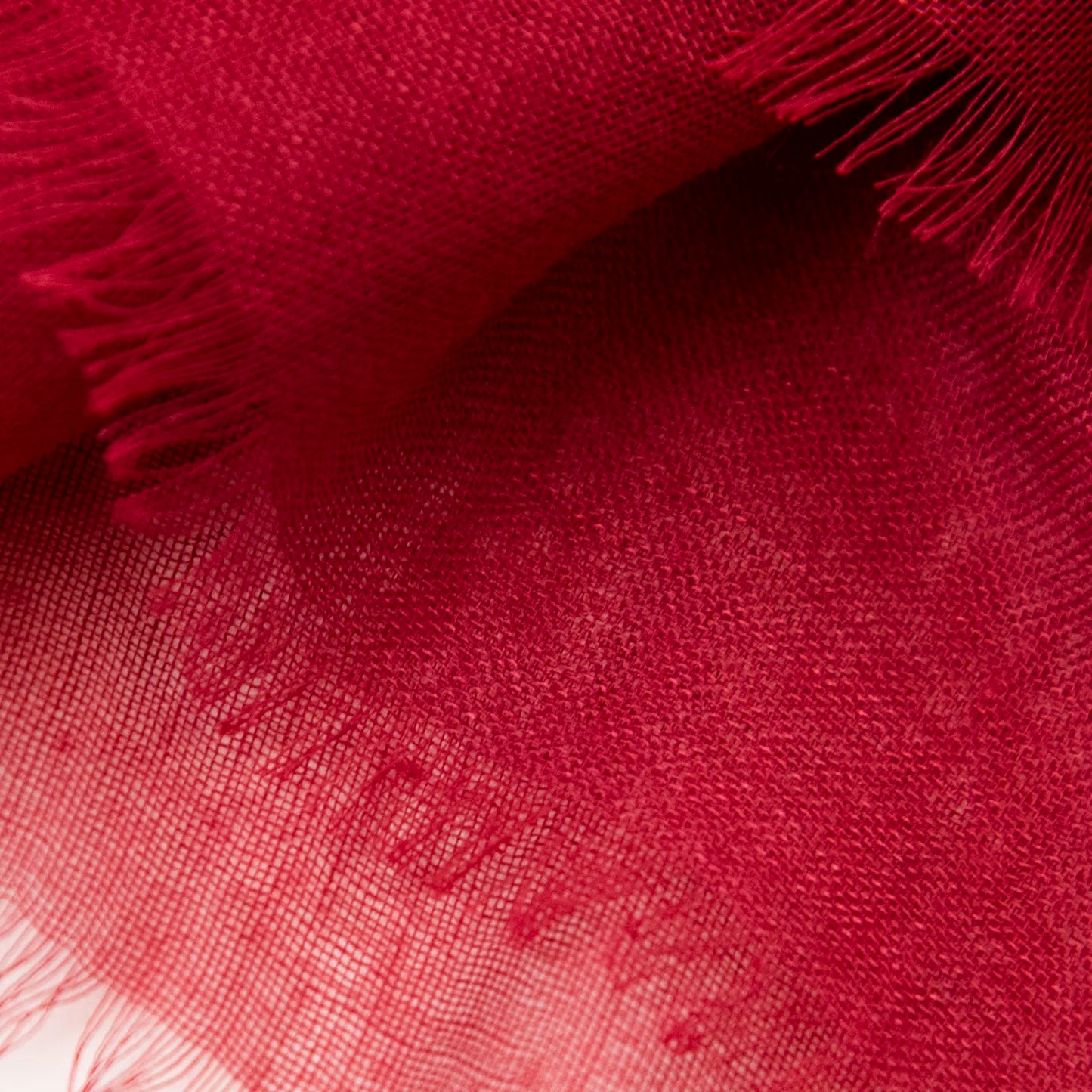 Dettagli e texture della Pashmina in cashmere e modal bordeaux a tessitura twill, pregiata manifattura Made in Italy, sottile ed elegante adatta a ogni stagione.