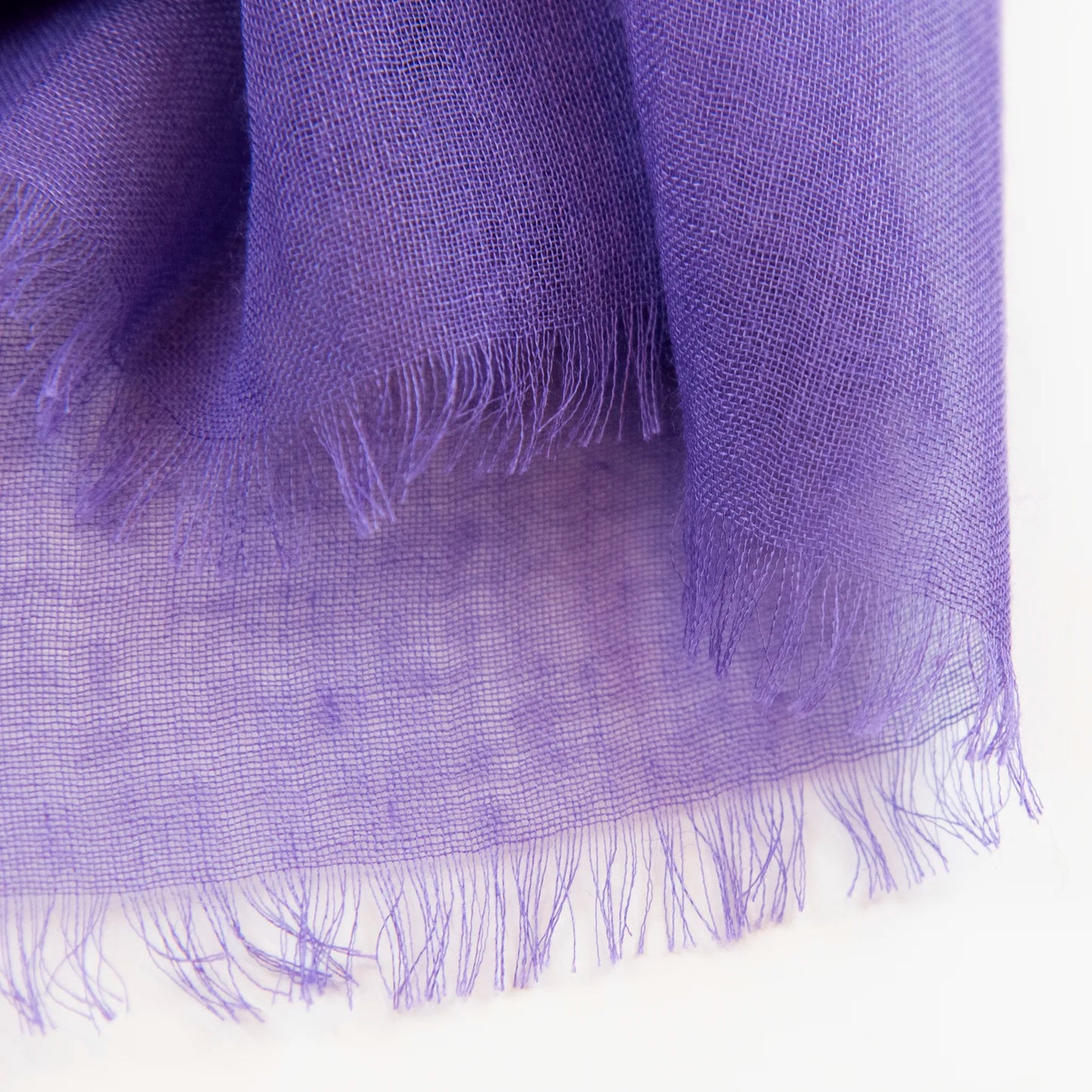 Dettagli e texture della Pashmina in cashmere e modal viola a tessitura twill, pregiata manifattura Made in Italy, sottile ed elegante adatta a ogni stagione.