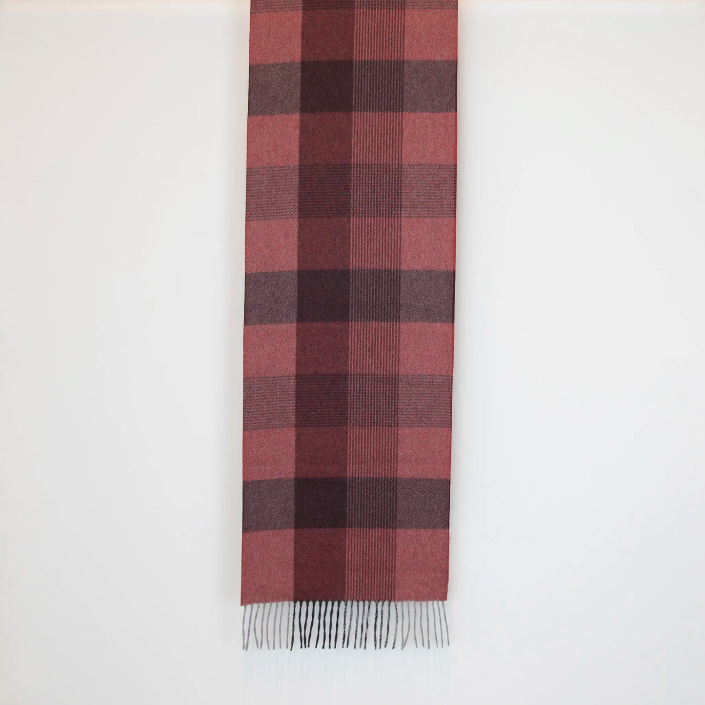 Sciarpa in cashmere e seta, rossa e bordeaux, Made in Italy, con pattern geometrico a quadri e scacchi in tonalità calde. Il design equilibrato e raffinato, unito alla combinazione cromatica, la rende facilmente abbinabile in ogni occasione. Morbida e confortevole, questa sciarpa offre calore e leggerezza. Un accessorio versatile, frutto della creatività di designer specializzati, perfetto per aggiungere un tocco elegante a qualsiasi look.