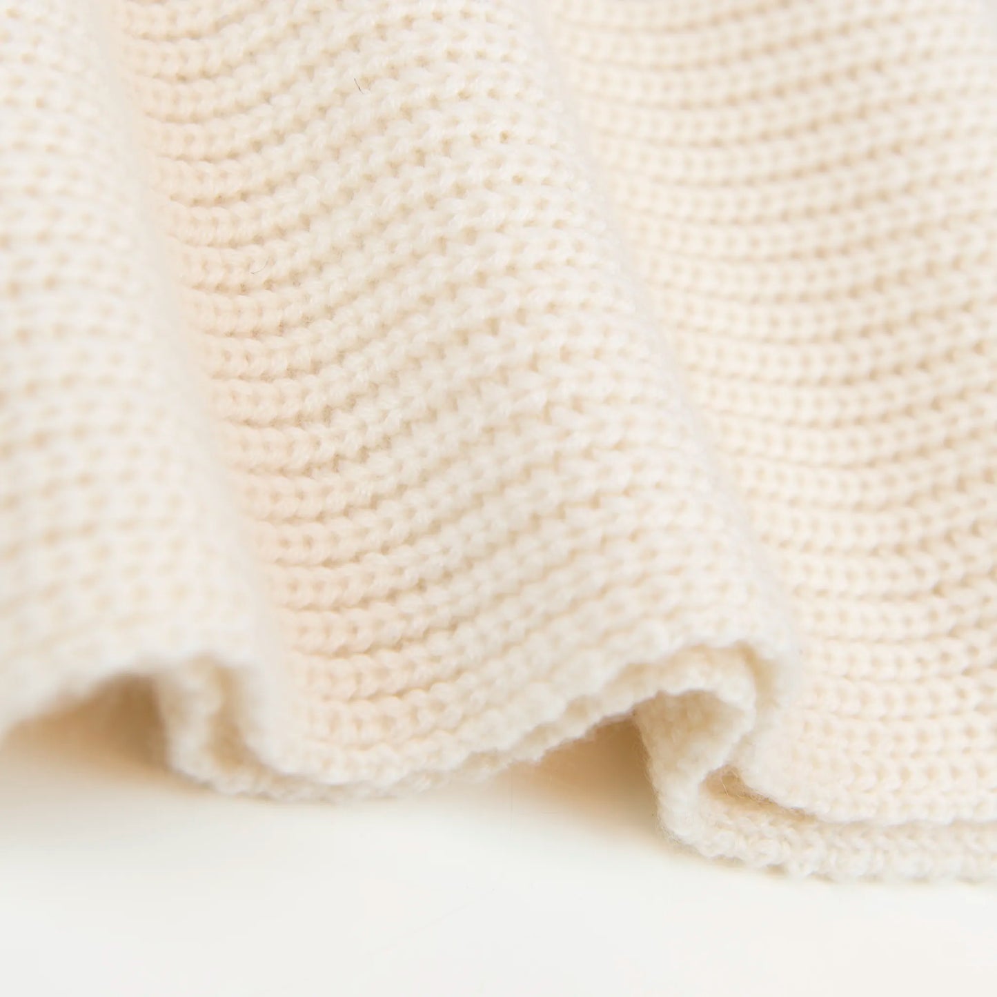 Dettaglio e texture tessuto della sciarpa in 100% cashmere panna, Made in Italy, realizzata su telai antichi con trama a nodo perlato. La morbidezza eccezionale e l'effetto compatto e voluminoso della texture conferiscono al filato un calore avvolgente, ideale per le stagioni più fredde. Un accessorio di alta qualità che unisce eleganza e comfort, perfetto per aggiungere un tocco di lusso al tuo look.