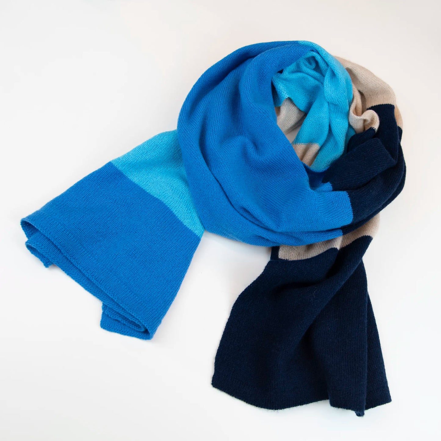 Sciarpa in maglia 100% cashmere blu e beige, Made in Italy, realizzata su antichi telai. Grazie alla sua ampiezza, può essere utilizzata anche come stola. La pregiata fibra di cashmere offre un'eccezionale finezza e qualità termoisolanti, assicurando calore, protezione e leggerezza in tutte le stagioni. Un accessorio versatile, frutto della creatività di designer specializzati, che aggiunge eleganza e comfort al tuo look.