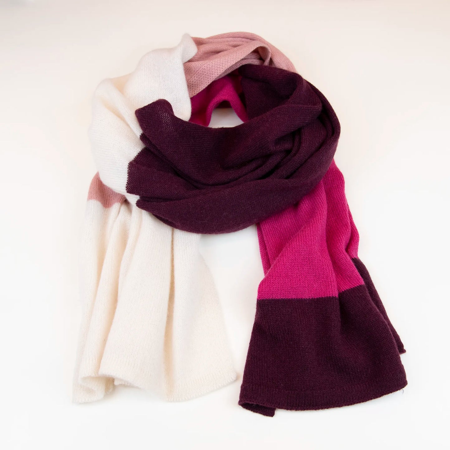 Sciarpa in maglia 100% cashmere rosa, viola e fucsia, Made in Italy, realizzata su antichi telai. Grazie alla sua ampiezza, può essere utilizzata anche come stola. La pregiata fibra di cashmere offre un'eccezionale finezza e qualità termoisolanti, assicurando calore, protezione e leggerezza in tutte le stagioni. Un accessorio versatile, frutto della creatività di designer specializzati, che aggiunge eleganza e comfort al tuo look.