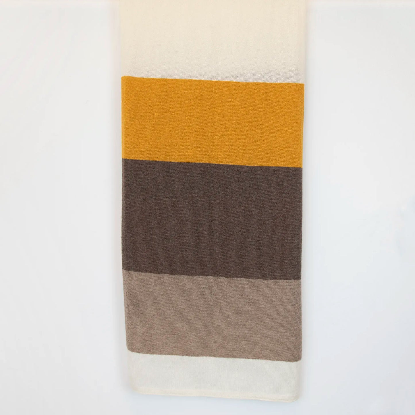 Sciarpa in maglia 100% cashmere senape, beige e marrone, Made in Italy, realizzata su antichi telai. Grazie alla sua ampiezza, può essere utilizzata anche come stola. La pregiata fibra di cashmere offre un'eccezionale finezza e qualità termoisolanti, assicurando calore, protezione e leggerezza in tutte le stagioni. Un accessorio versatile, frutto della creatività di designer specializzati, che aggiunge eleganza e comfort al tuo look.