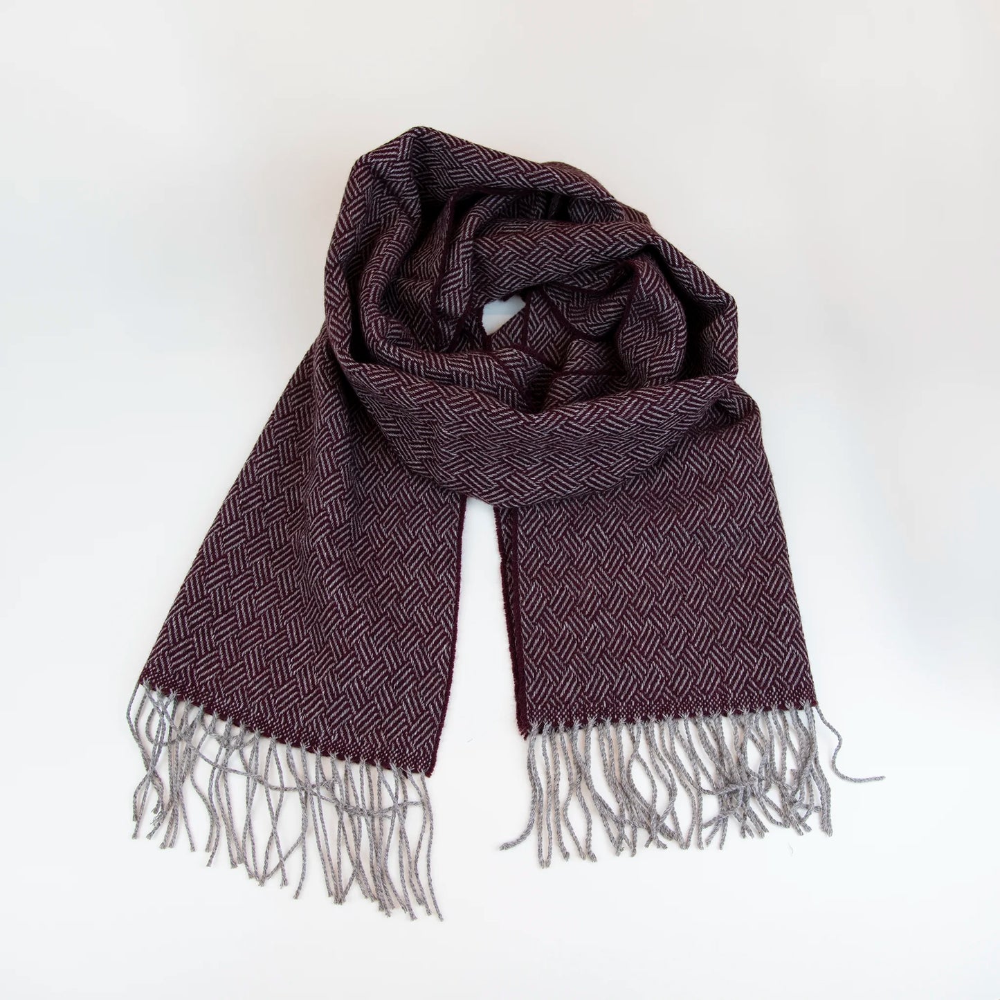 Sciarpa in 100% cashmere bordeaux, Made in Italy, con intramontabile pattern ad intreccio e lavorazione leggera in 3D che accentua la percezione al tatto. Il cashmere di alta qualità offre straordinaria finezza, proprietà termoisolanti e garantisce calore, protezione e leggerezza.