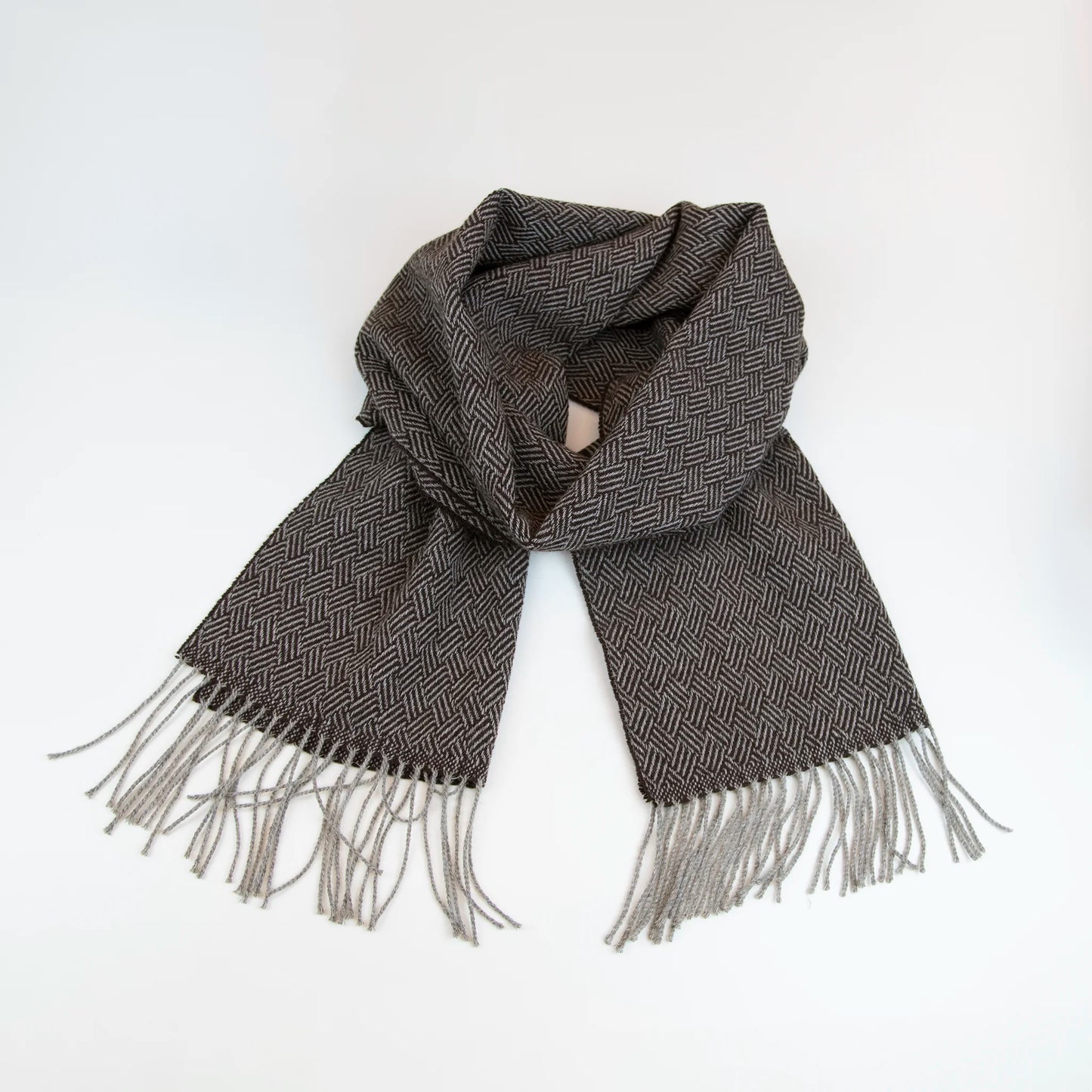 Sciarpa in 100% cashmere marrone, Made in Italy, con intramontabile pattern ad intreccio e lavorazione leggera in 3D che accentua la percezione al tatto. Il cashmere di alta qualità offre straordinaria finezza, proprietà termoisolanti e garantisce calore, protezione e leggerezza.