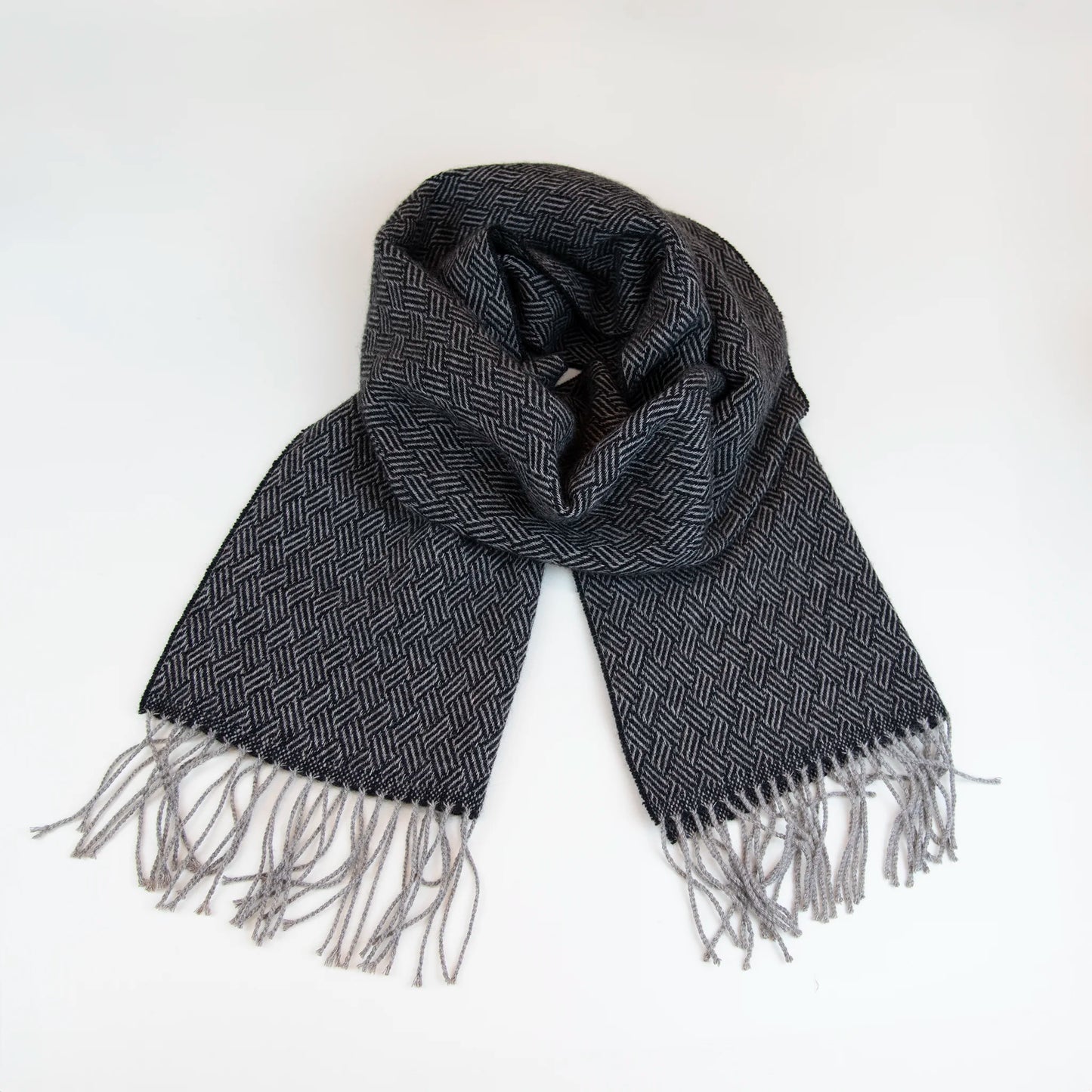 Sciarpa in 100% cashmere nera, Made in Italy, con intramontabile pattern ad intreccio e lavorazione leggera in 3D che accentua la percezione al tatto. Il cashmere di alta qualità offre straordinaria finezza, proprietà termoisolanti e garantisce calore, protezione e leggerezza.