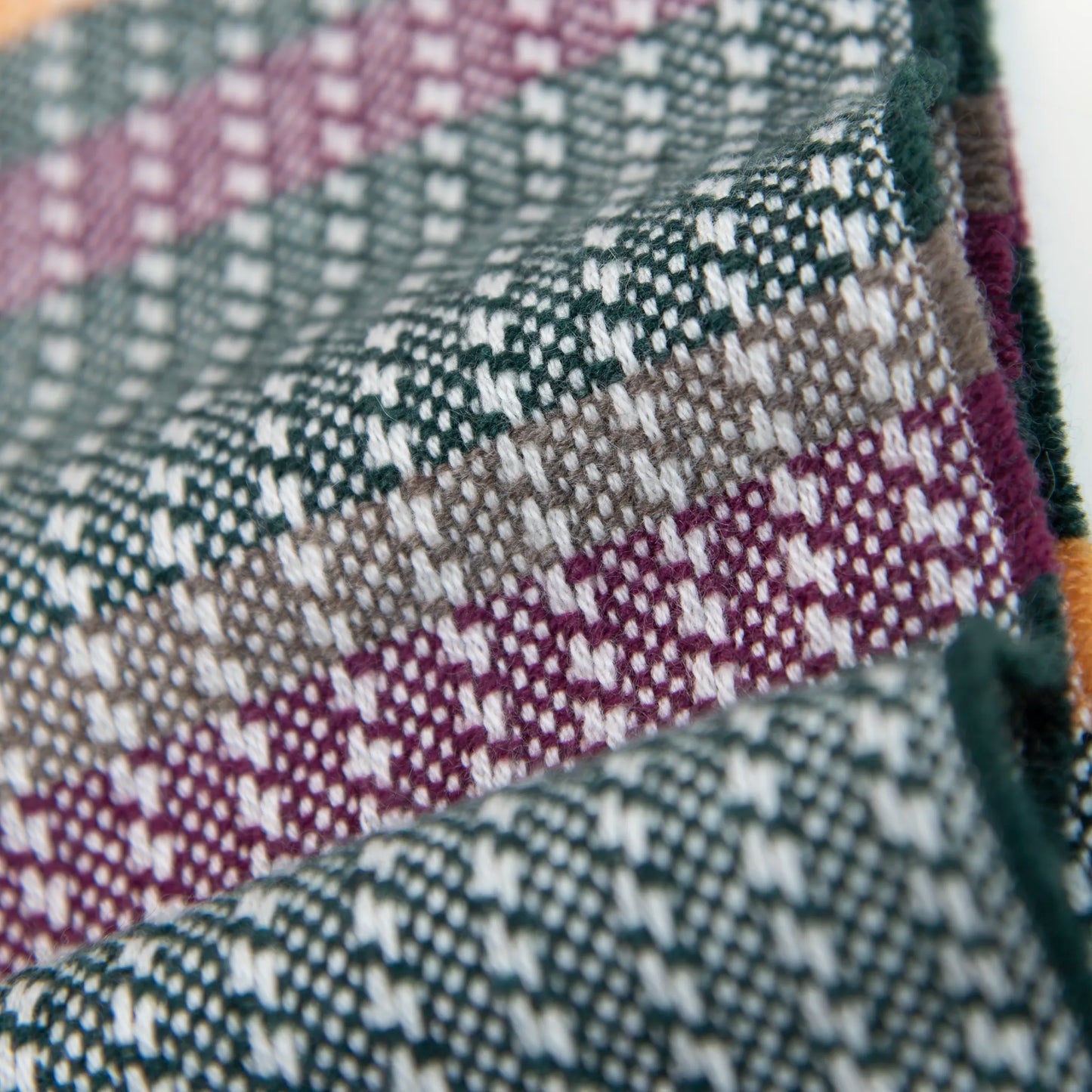 Dettaglio e texture tessuto della sciarpa in 100% cashmere, realizzata in Italia con ricamo 3D su filato naturale, senza pigmenti. Lavorazione artigianale su telai antichi garantisce durata e qualità. Design esclusivo, con colori creati da designer per un capo elegante e versatile.