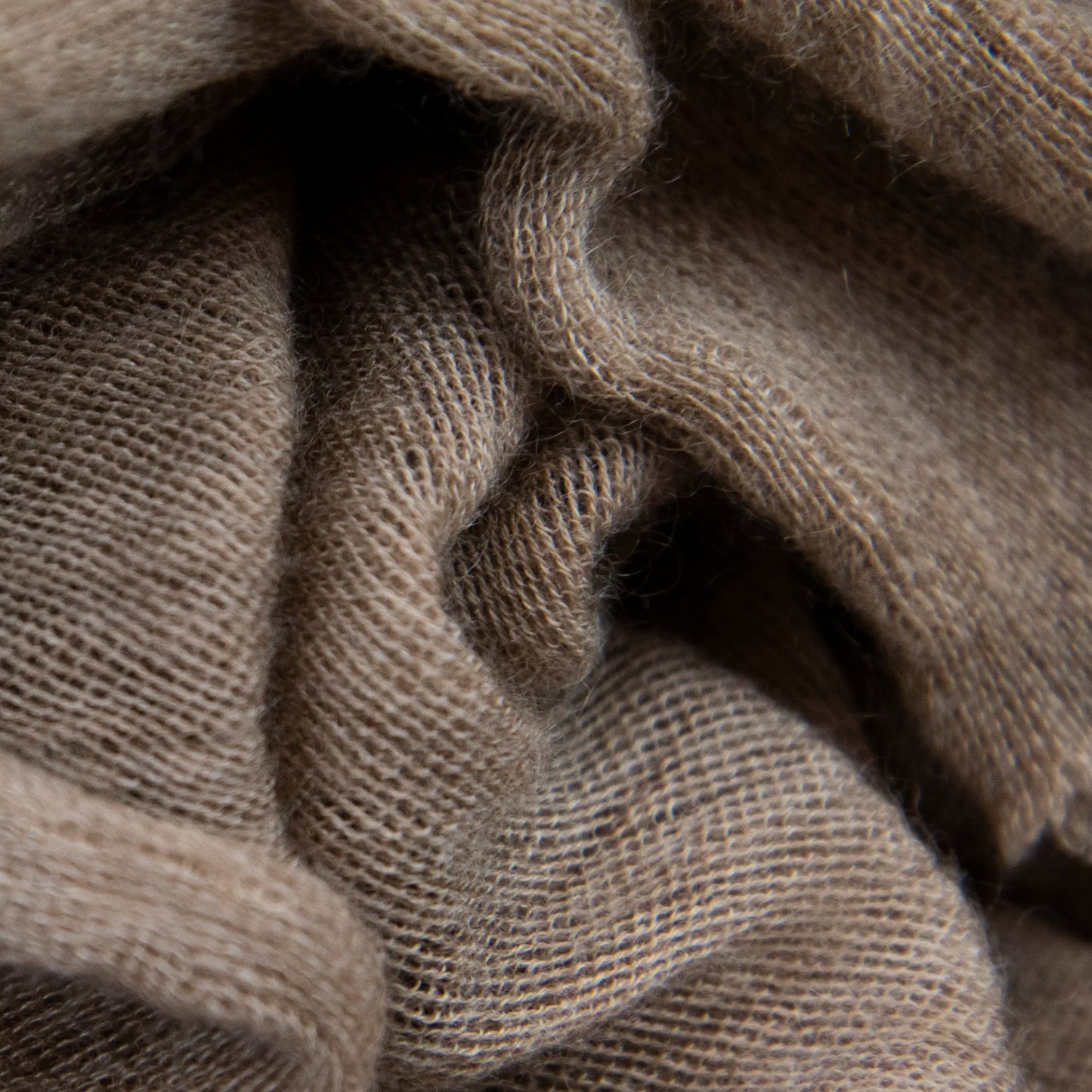 Dettagli e texture tessuto della pashmina marrone in 100% cashmere Made in Italy, tessitura a jersey, leggera e vaporosa, perfetta come sciarpa o stola per tutte le stagioni.
