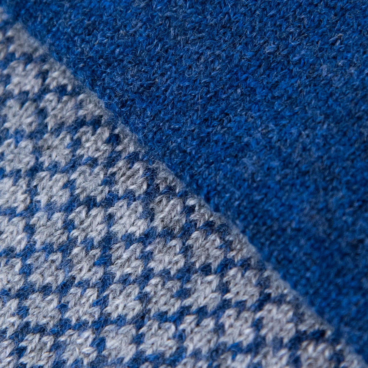 Dettagli e texture della sciarpa scaldacollo Jacquard double-face blu e grigia con asola in 100% Cashmere beige. Morbida, versatile e facile da indossare.