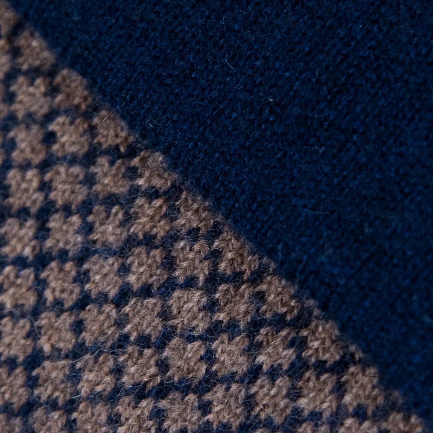 Dettagli e texture della sciarpa scaldacollo Jacquard double-face blu e marrone con asola in 100% Cashmere beige. Morbida, versatile e facile da indossare.
