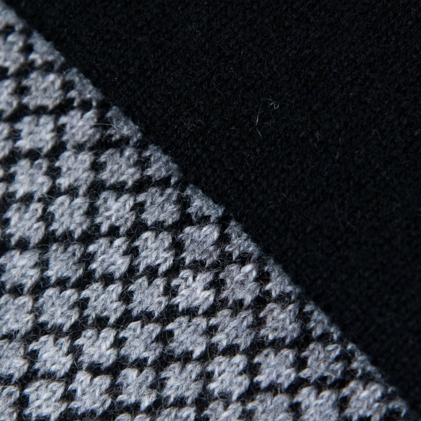 Dettagli e texture tessuto della sciarpa scaldacollo Jacquard double-face nera e grigia con asola in 100% Cashmere beige. Morbida, versatile e facile da indossare.