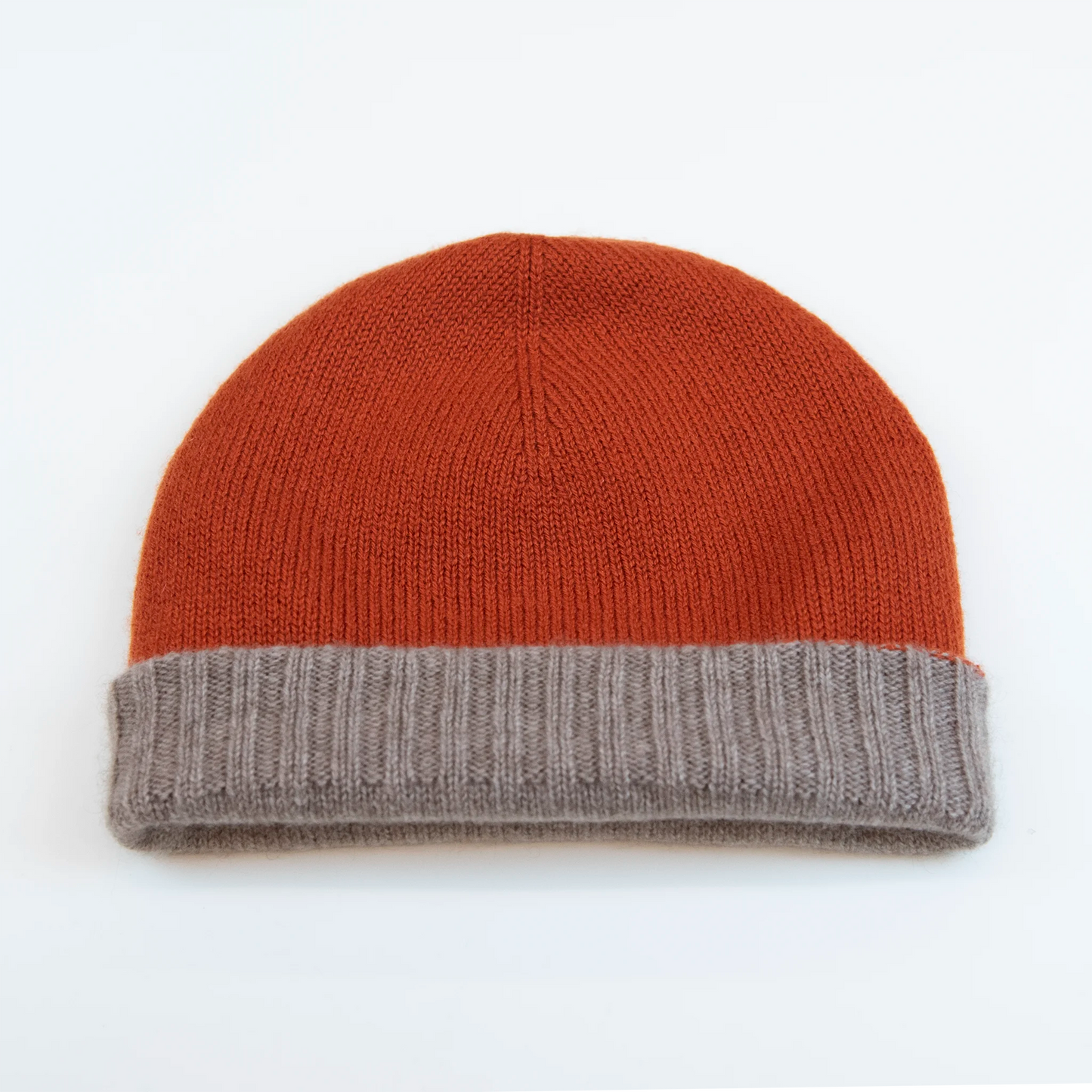 Cuffia doubleface arancio e beige in 100% Cashmere, Made in Italy. Pratica e versatile, può essere indossata con o senza risvolto. Trama rasata e pregiata manifattura per una vestibilità confortevole e di qualità.