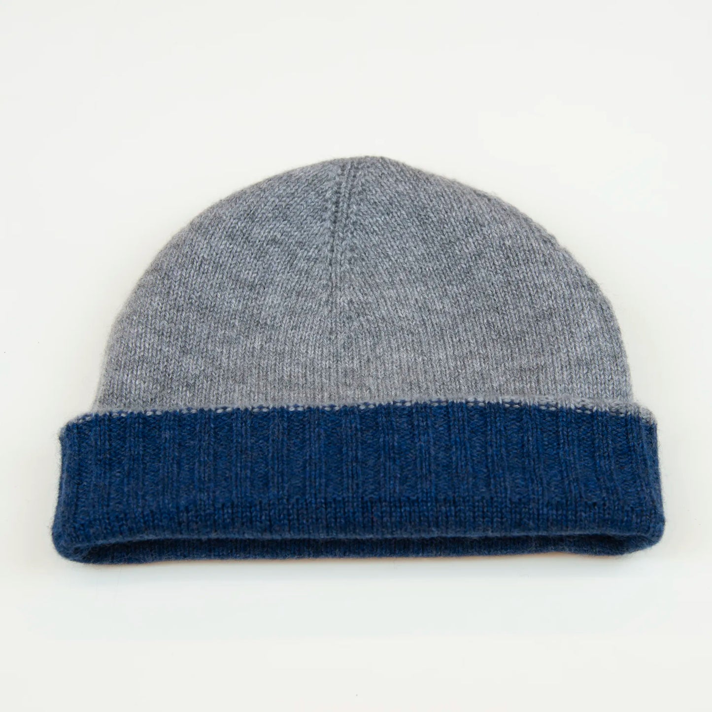 Cuffia doubleface grigio e blu in 100% Cashmere, Made in Italy. Pratica e versatile, può essere indossata con o senza risvolto. Trama rasata e pregiata manifattura per una vestibilità confortevole e di qualità.