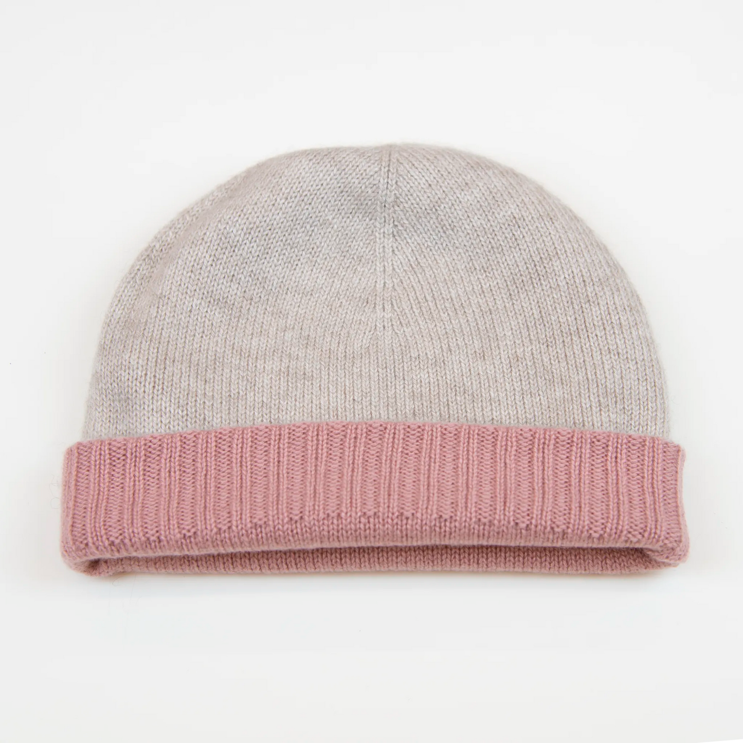 Cuffia doubleface rosa e panna in 100% Cashmere, Made in Italy. Pratica e versatile, può essere indossata con o senza risvolto. Trama rasata e pregiata manifattura per una vestibilità confortevole e di qualità.
