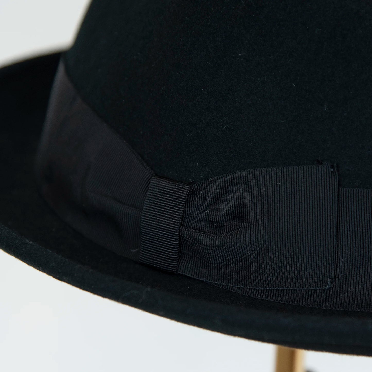 Dettaglio cinta e tessuto del cappello in feltro di lana nero, Made in Italy, falda corta 5 cm e cinta in gros-grain nera. Parte della Collezione Emporio San Felice, elegante e versatile per ogni occasione.