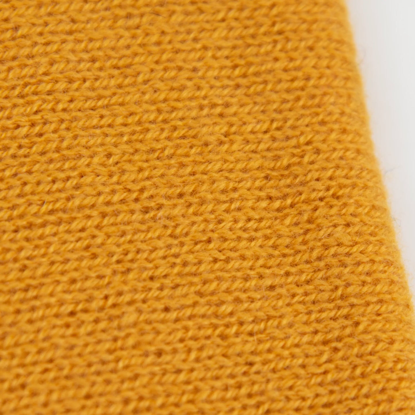 Dettaglio e texture tessuto del Collo in 100% cashmere color senape, versatile, utilizzabile come scaldacollo, fascia per capelli, passamontagna o cappello con sbuffo, Made in Italy, morbido e caldo.