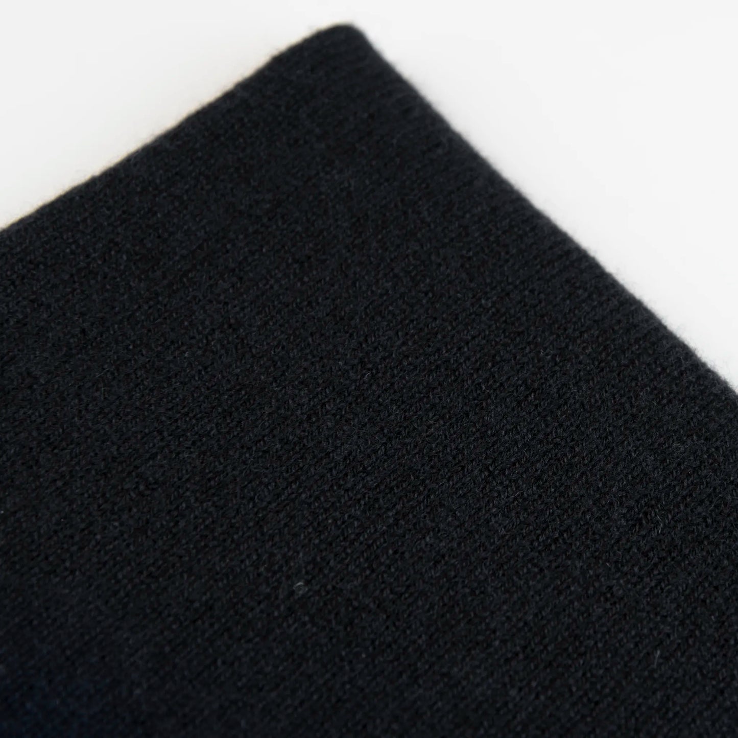 Dettaglio e texture tessuto del Collo in 100% cashmere nero, versatile, utilizzabile come scaldacollo, fascia per capelli, passamontagna o cappello con sbuffo, Made in Italy, morbido e caldo.