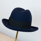 Cappello in 100% lapin blu, Made in Italy, realizzato su antiche forme in legno. Ispirato ai primi del '900, con cupola alta 13,5 cm e cinta nera di 5 cm per uno stile iconico.