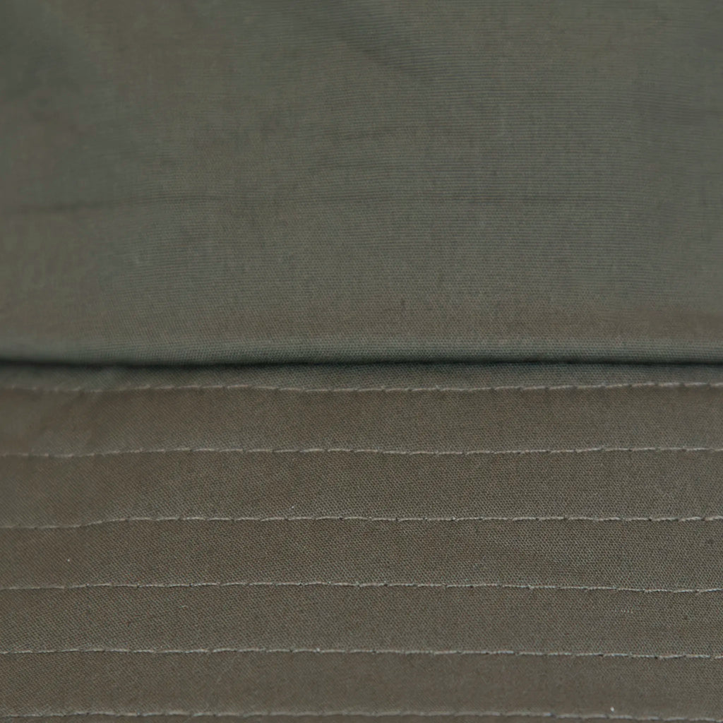 Dettaglio tessuto del cappello antipioggia bucket verde con cuciture termosaldate, impermeabile, facile da conservare in borsa o tasca mantenendo la forma. Made in Italy
