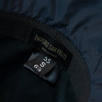 Dettaglio e texture del tessuto del cappello antipioggia cloche blu impermeabile con falda lunga 9cm, pratico da conservare in borsa o tasca mantenendo la forma.