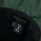 Dettaglio e texture del tessuto del cappello antipioggia cloche verde impermeabile con falda lunga 9cm, pratico da conservare in borsa o tasca mantenendo la forma.
