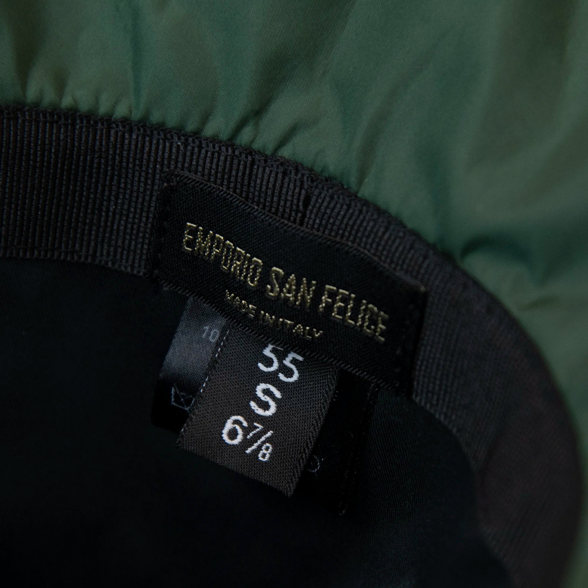 Dettaglio e texture del tessuto del cappello antipioggia cloche verde impermeabile con falda lunga 9cm, pratico da conservare in borsa o tasca mantenendo la forma.