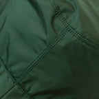 Dettaglio e texture del tessuto del cappello antipioggia cloche verde impermeabile con falda lunga 9cm, pratico da conservare in borsa o tasca mantenendo la forma.
