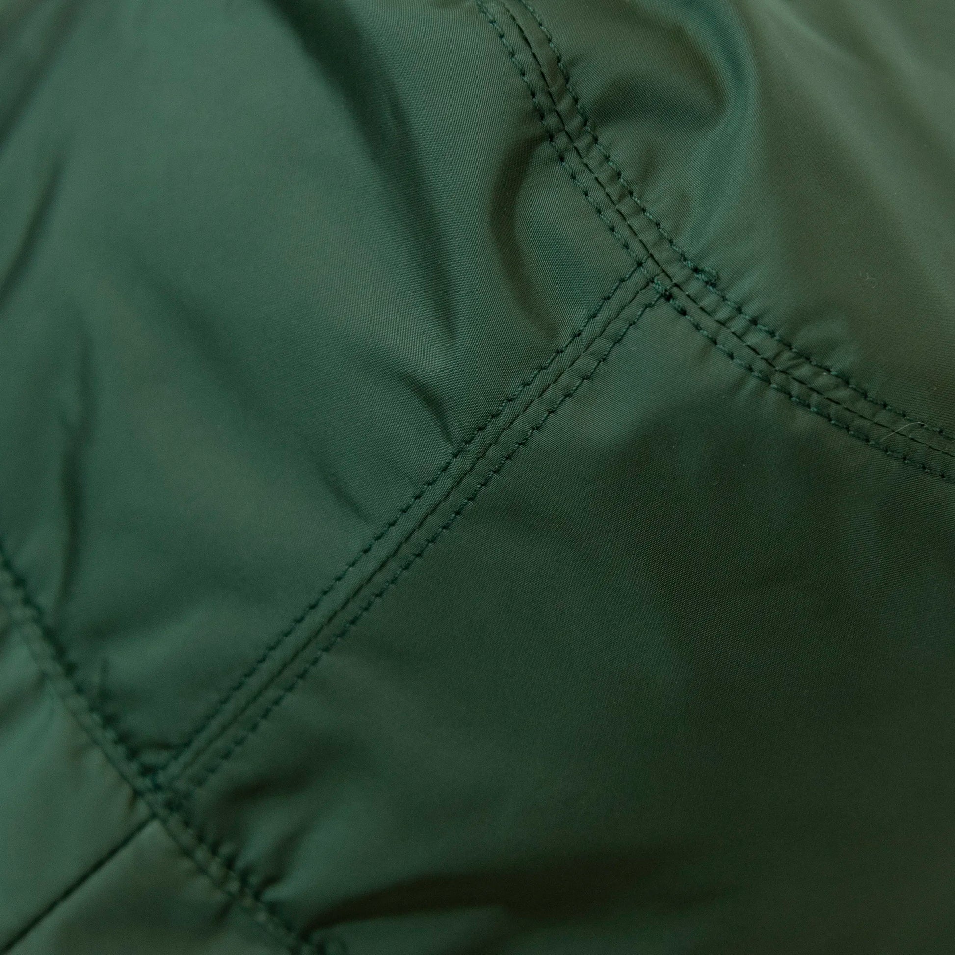 Dettaglio e texture del tessuto del cappello antipioggia cloche verde impermeabile con falda lunga 9cm, pratico da conservare in borsa o tasca mantenendo la forma.