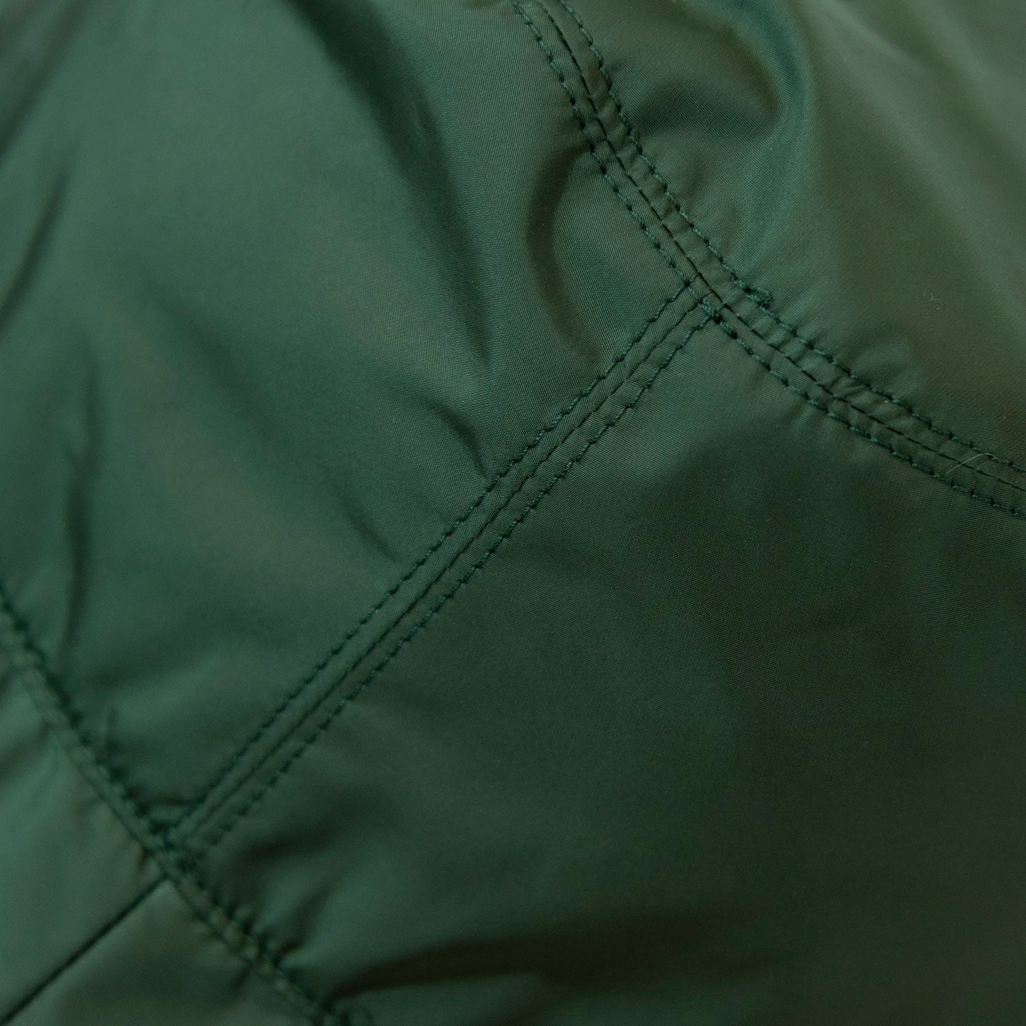 Dettaglio e texture del tessuto del cappello antipioggia cloche verde impermeabile con falda lunga 9cm, pratico da conservare in borsa o tasca mantenendo la forma.
