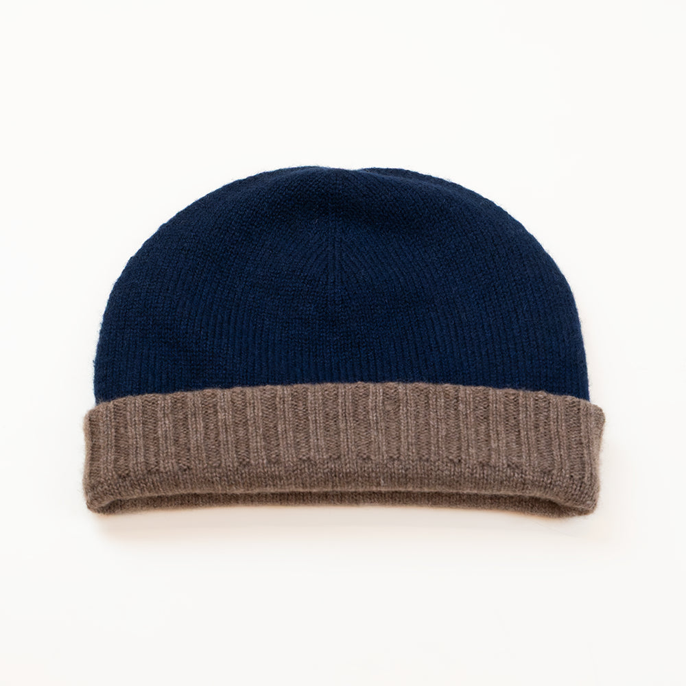 Cuffia doubleface marrone e blu in 100% Cashmere, Made in Italy. Pratica e versatile, può essere indossata con o senza risvolto. Trama rasata e pregiata manifattura per una vestibilità confortevole e di qualità.