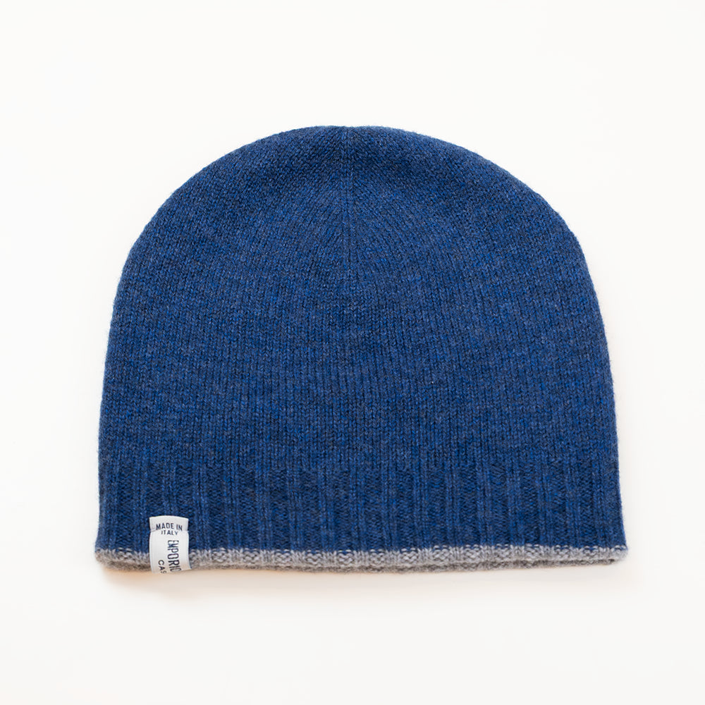 Cuffia doubleface grigio e blu in 100% Cashmere, Made in Italy. Pratica e versatile, può essere indossata con o senza risvolto. Trama rasata e pregiata manifattura per una vestibilità confortevole e di qualità.