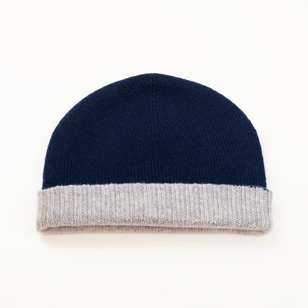 Cuffia doubleface grigio e blu in 100% Cashmere, Made in Italy. Pratica e versatile, può essere indossata con o senza risvolto. Trama rasata e pregiata manifattura per una vestibilità confortevole e di qualità.