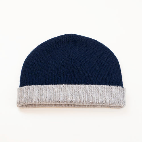 Cuffia doubleface grigio e blu in 100% Cashmere, Made in Italy. Pratica e versatile, può essere indossata con o senza risvolto. Trama rasata e pregiata manifattura per una vestibilità confortevole e di qualità.