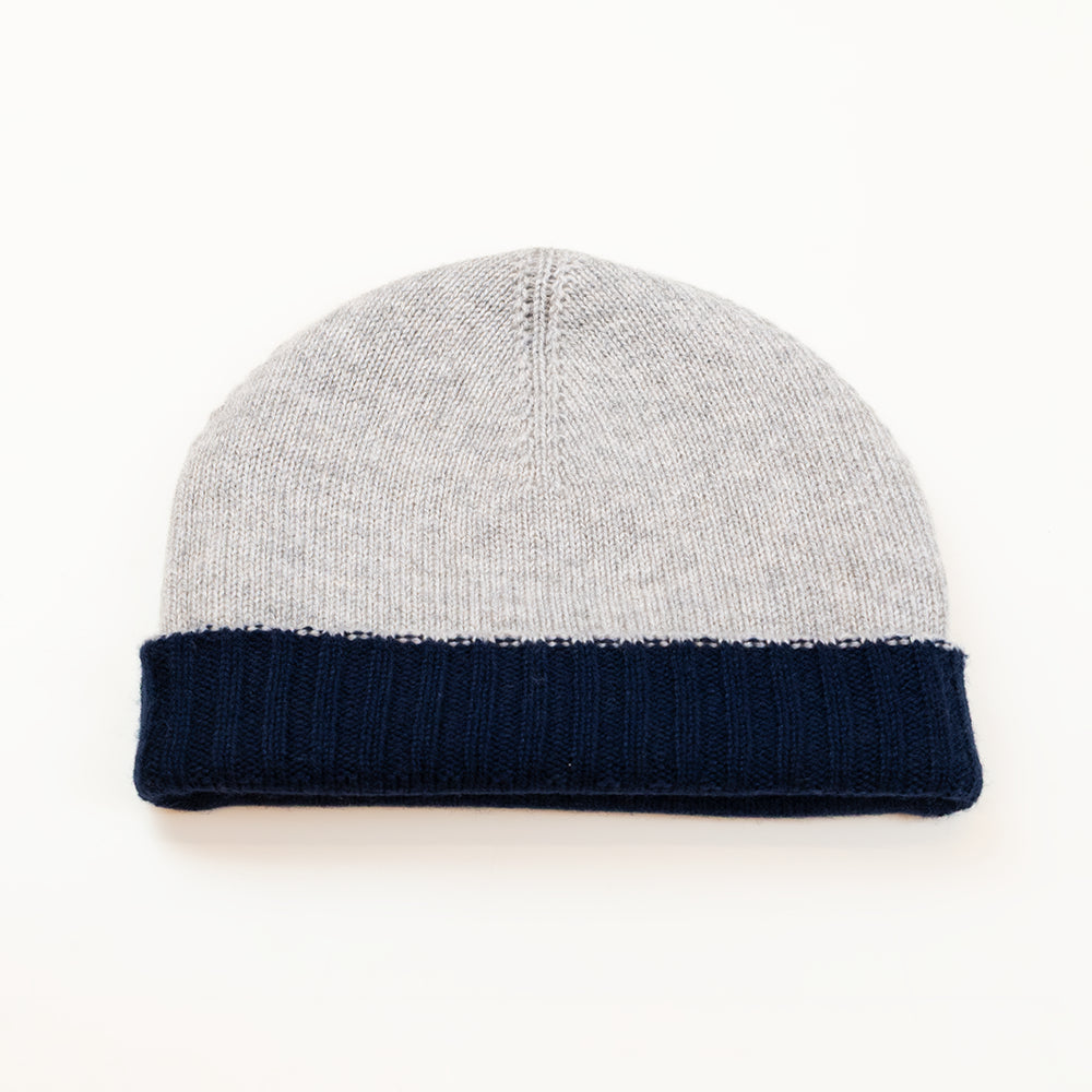 Cuffia doubleface grigio e blu in 100% Cashmere, Made in Italy. Pratica e versatile, può essere indossata con o senza risvolto. Trama rasata e pregiata manifattura per una vestibilità confortevole e di qualità.