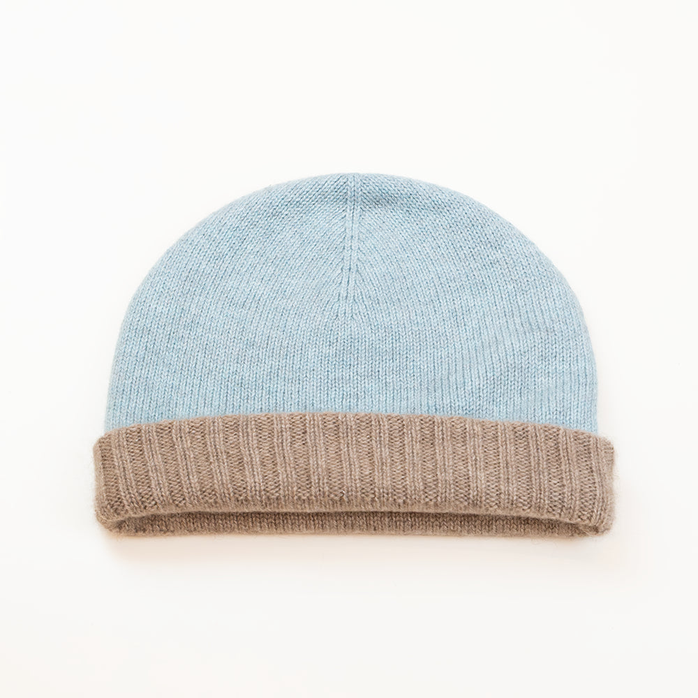 Cuffia doubleface beige e celeste in 100% Cashmere, Made in Italy. Pratica e versatile, può essere indossata con o senza risvolto. Trama rasata e pregiata manifattura per una vestibilità confortevole e di qualità.