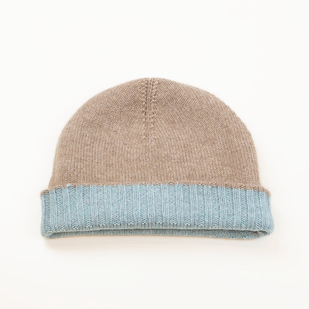 Cuffia doubleface beige e celeste in 100% Cashmere, Made in Italy. Pratica e versatile, può essere indossata con o senza risvolto. Trama rasata e pregiata manifattura per una vestibilità confortevole e di qualità.
