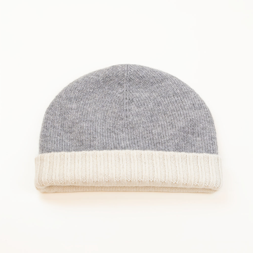 Cuffia doubleface grigio e panna in 100% Cashmere, Made in Italy. Pratica e versatile, può essere indossata con o senza risvolto. Trama rasata e pregiata manifattura per una vestibilità confortevole e di qualità.