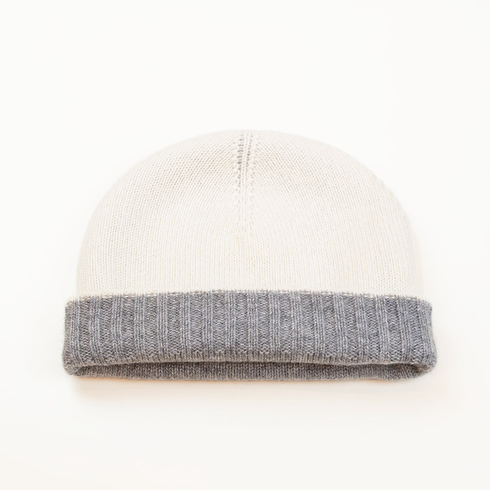 Cuffia doubleface grigio e panna in 100% Cashmere, Made in Italy. Pratica e versatile, può essere indossata con o senza risvolto. Trama rasata e pregiata manifattura per una vestibilità confortevole e di qualità.
