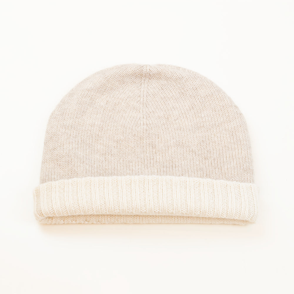 Cuffia doubleface panna e beige in 100% Cashmere, Made in Italy. Pratica e versatile, può essere indossata con o senza risvolto. Trama rasata e pregiata manifattura per una vestibilità confortevole e di qualità.