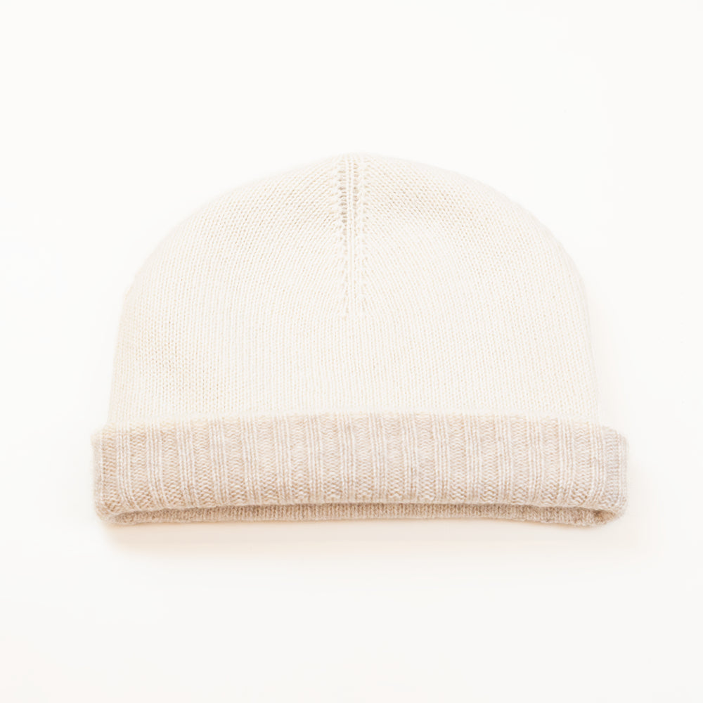 Cuffia doubleface panna e beige in 100% Cashmere, Made in Italy. Pratica e versatile, può essere indossata con o senza risvolto. Trama rasata e pregiata manifattura per una vestibilità confortevole e di qualità.