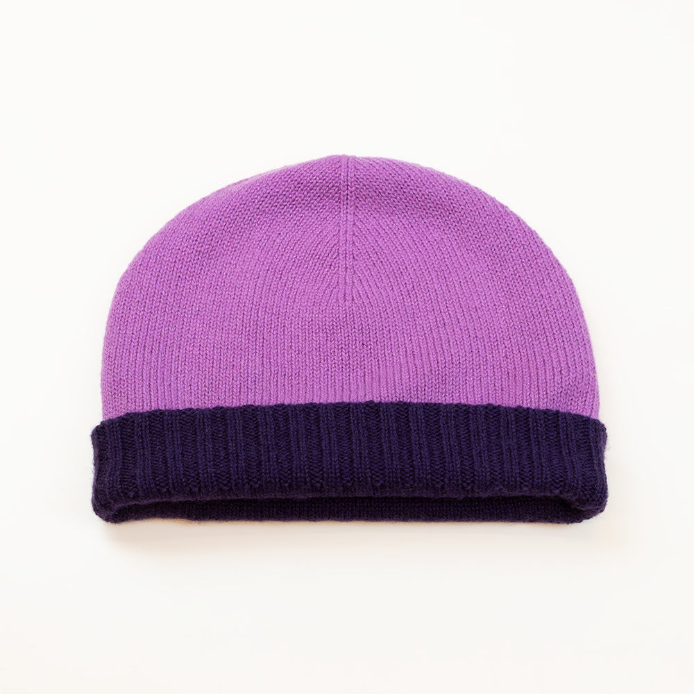 Cuffia doubleface viola melanzana e rosa in 100% Cashmere, Made in Italy. Pratica e versatile, può essere indossata con o senza risvolto. Trama rasata e pregiata manifattura per una vestibilità confortevole e di qualità.