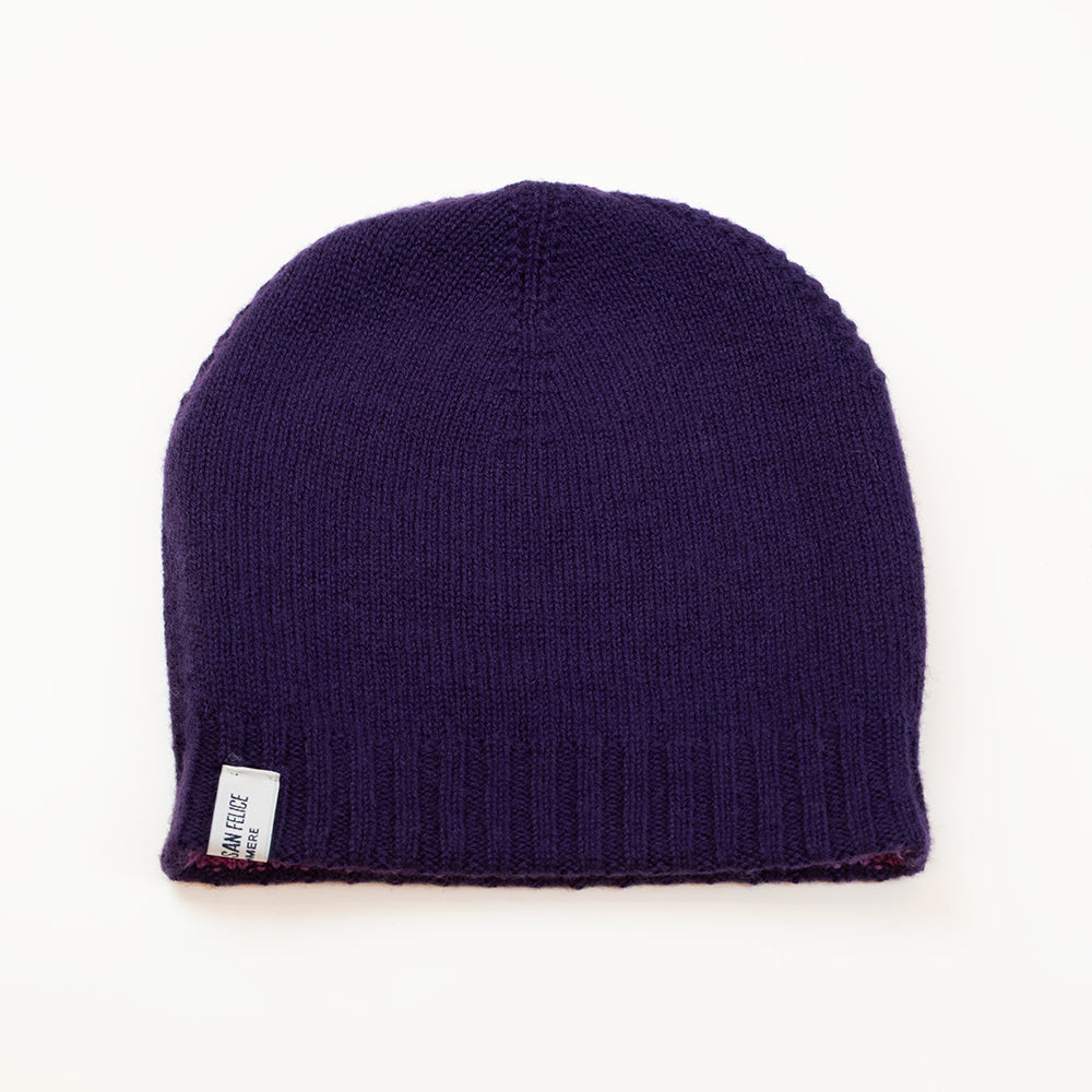 Cuffia doubleface viola melanzana e rosa in 100% Cashmere, Made in Italy. Pratica e versatile, può essere indossata con o senza risvolto. Trama rasata e pregiata manifattura per una vestibilità confortevole e di qualità.