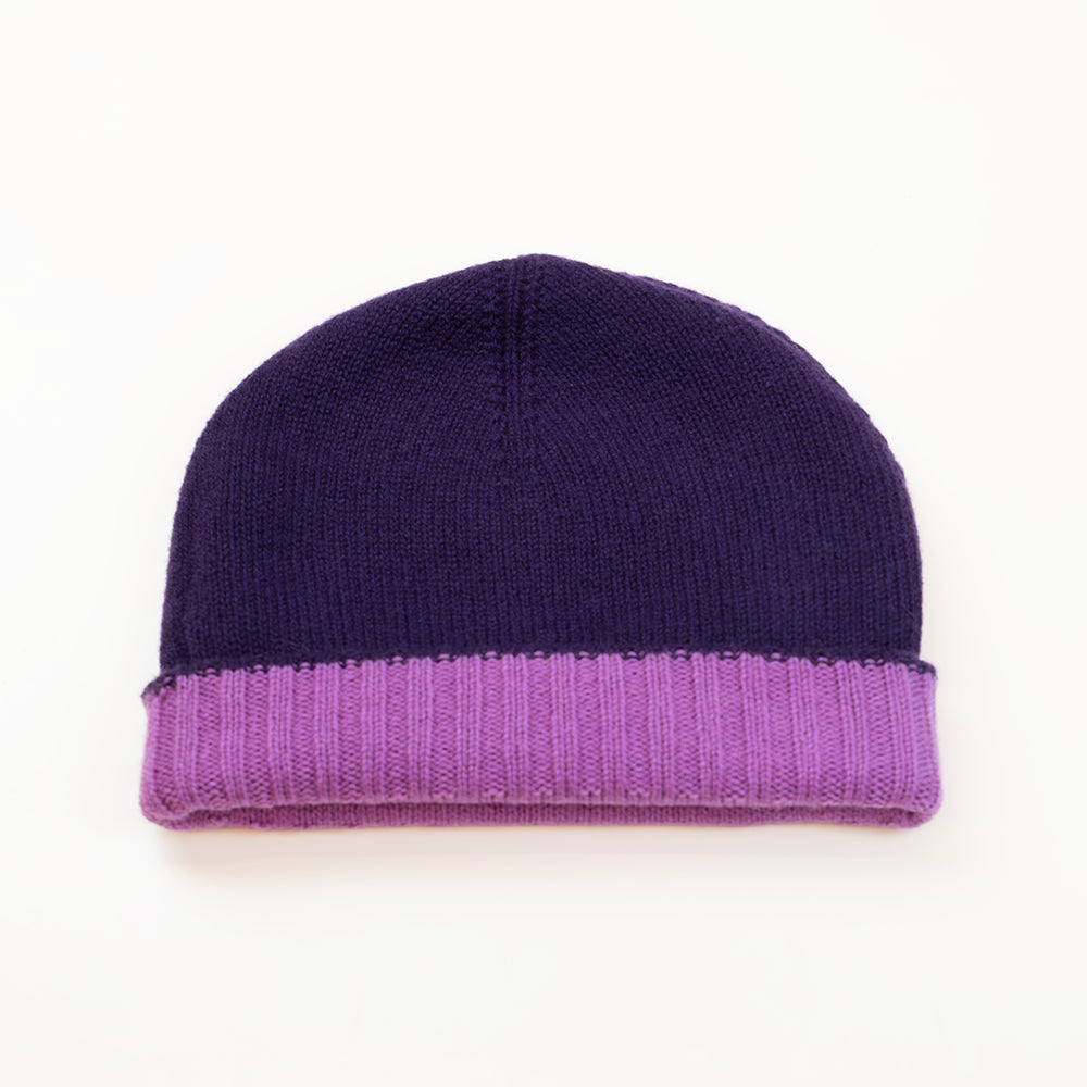 Cuffia doubleface viola melanzana e rosa in 100% Cashmere, Made in Italy. Pratica e versatile, può essere indossata con o senza risvolto. Trama rasata e pregiata manifattura per una vestibilità confortevole e di qualità.